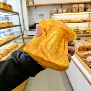 Close-up of a slow-rebound squishy toast toy being squeezed for stress relief.