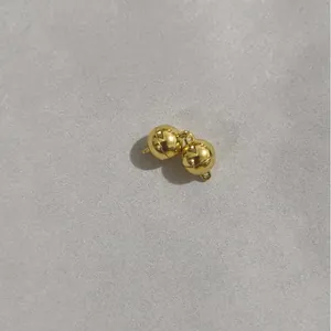 Vista ravvicinata di due chiusure magnetiche sferiche lucide placcate in oro 14k