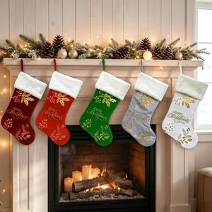 Detailed view of five colorful velvet Christmas stockings with gold Merry Christmas embroidery