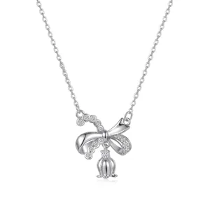 Détail d'un collier en argent fin avec un pendentif nœud et un lys en cristal