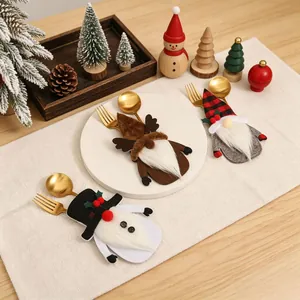 Ein Set aus drei festlichen Weihnachtszwerg-Besteckhaltern auf einem dekorierten Tisch