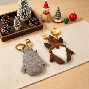 Festliche Weihnachtswichtel-Besteckhalter mit goldenen Löffeln und Gabeln am Tisch