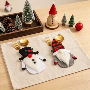 Zwei festliche Weihnachts-Gnom-Besteckhalter auf einem Tischset aus Leinenstoff