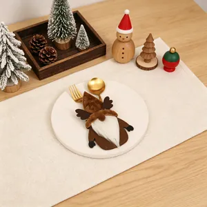 Detail eines Weihnachtsgnom Besteckhalters mit goldenem Löffel und Gabel auf Teller
