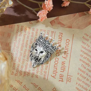 Vue détaillée d'une broche tête de lion en argent rétro avec strass couronne brillants