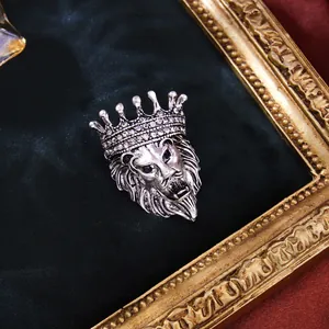 Gros plan d'une broche tête de lion vintage argentée avec couronne et strass brillants