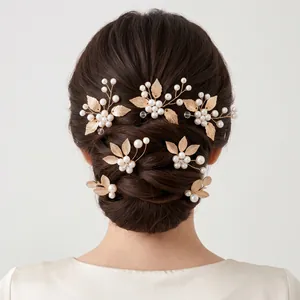 Detailed back view of elegant bridal hair pins set with golden leaves and white pearls