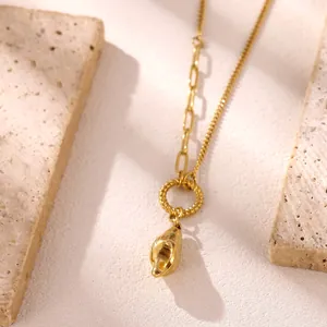 Dettaglio di una collana in acciaio inossidabile dorato con ciondolo a conchiglia reale