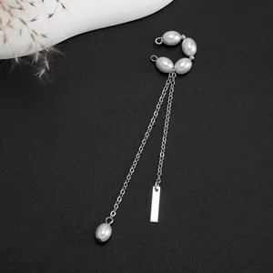 Detail view of silver tassel ear cuff with white pearls and minimalist metal bar