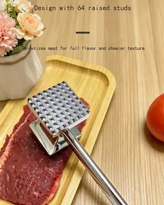 Close-up of stainless steel meat tenderizer hammer with 64 raised studs on raw steak