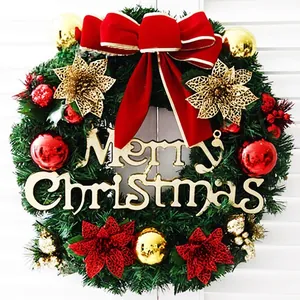 Detailed view of a lush Christmas wreath with red bow and gold Merry Christmas sign