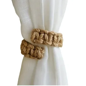 Detailed view of handmade woven jute curtain tieback wrapped around a white sheer curtain