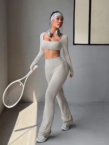 Asian model in grey Y2K long sleeve crop top and flared leggings, holding a tennis racket.