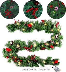 Detailed view of artificial Christmas garland with red berries and warm LED lights