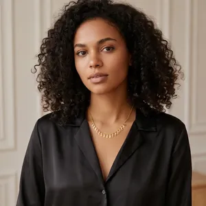 Elegant gold choker necklace with copper oval disc tassels worn by a model in black silk shirt