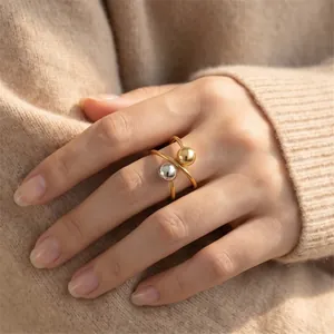 Detailed view of irregular geometric stainless steel ring with gold and silver spheres.