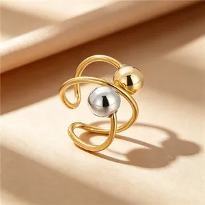 Macro view of stainless steel planet ring with polished gold and silver beads