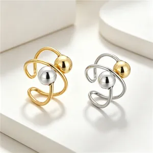 Two-tone geometric planet rings made of stainless steel with gold and silver beads.