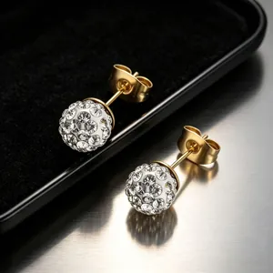 Vue macro de boucles d'oreilles Shamballa en acier doré serties de strass brillants