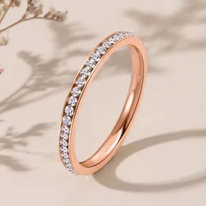 Elegant rose gold stainless steel ring featuring a half-eternity band of sparkling crystals