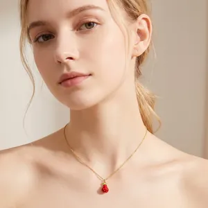 Elegant close-up of a sweet strawberry pendant necklace worn by a model in soft light