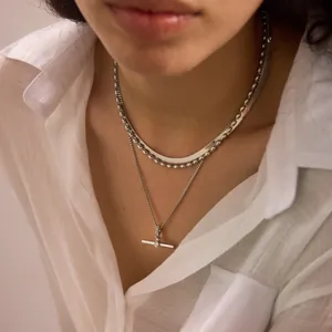 Detail view of layered silver stainless steel necklaces with a minimalist T-bar pendant