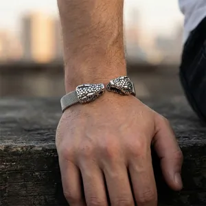 Nahaufnahme eines silbernen Punk Schlangenkopf Armbands aus Titanstahl am Handgelenk
