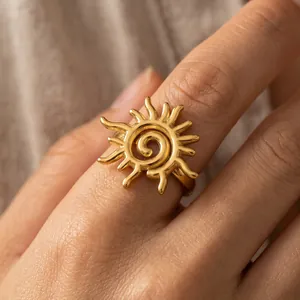 Eleganter goldener Edelstahl-Sonnenring mit spiralförmigem Zentrum an einem weiblichen Finger