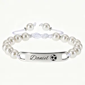 Vue détaillée d'un bracelet en perles blanches avec plaque en acier inoxydable gravée sur mesure
