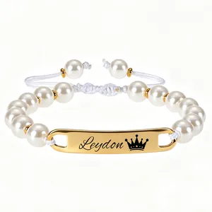 Vue détaillée de la plaque dorée personnalisée sur un bracelet bébé avec perles