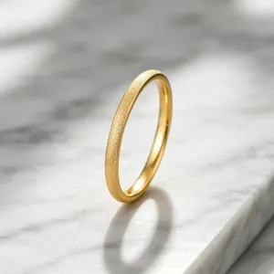 Detailed macro view of gold frosted titanium steel ring featuring a textured sparkling finish