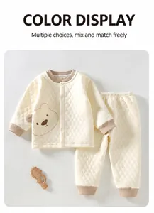 Detailed view of cream quilted three-layer warm baby clothing set with bear motif