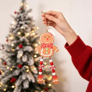 Hand holding a detailed wooden gingerbread man Christmas ornament with long bead legs.