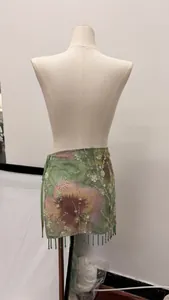 Close-up of floral print mini skirt featuring sequin embellishments and beaded fringe