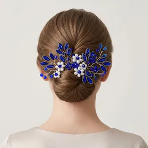 Detail view of handmade vintage hair comb with blue crystals and pearl flowers.