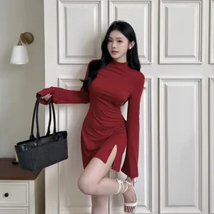 Robe rouge élégante à col montant et manches longues avec fente, coupe ajustée chic.