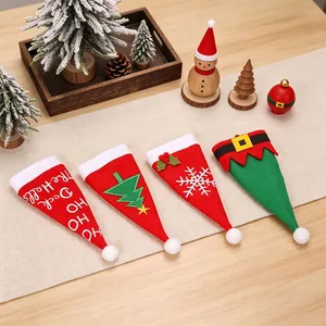 Lot de quatre porte-couverts de Noël en feutre sur un chemin de table de fête décoré