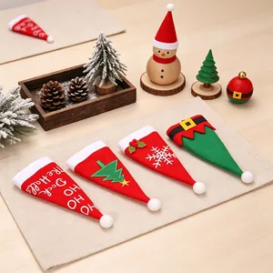 Détail des pochettes à couverts de Noël en tissu non tissé disposées sur un set de table.