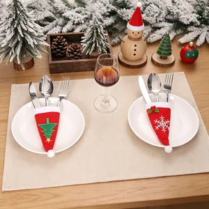 Porte-couverts de Noël festifs avec motifs de sapin et de flocon sur une table de fête.