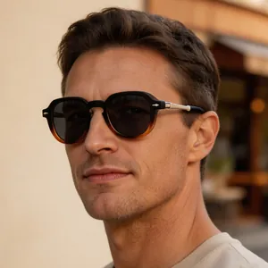 Close-up of retro square sunglasses on model in warm outdoor lighting.