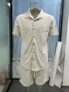 Close-up detail of a men's beige ribbed short-sleeve shirt and matching shorts.