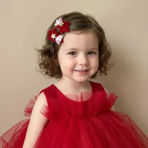 Adorable petite fille portant des barrettes étoiles en velours rouge avec rubans
