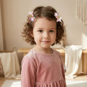 Fillette aux cheveux bouclés portant des barrettes étoile en velours rose avec glands