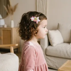 Détail d'une barrette étoile en velours rose avec ruban arc-en-ciel pour filles