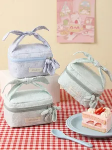 Floral embossed makeup bag featuring bow handle in pastel blue and mint green colors