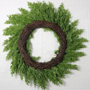Artificial green pine needle Christmas wreath on natural rattan ring for front door decor