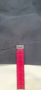 Macro detail shot showing garment hem measurement with a red tape measure tool.