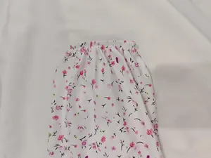Détail de la taille élastiquée et de l'imprimé floral rose sur le tissu de la robe d'été