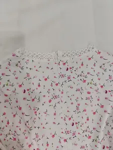 Gros plan d'une robe fleurie blanche avec dentelle et fermeture éclair invisible