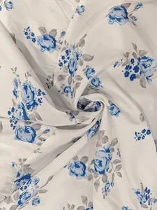 Detailed macro view of elegant blue floral rose pattern on white summer dress fabric